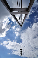 Crain with iron pendulum hook with blue sky.