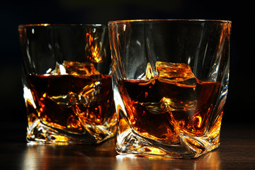 Glasses of whiskey, on dark background