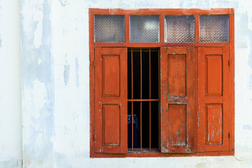 Red wooden window with white wall