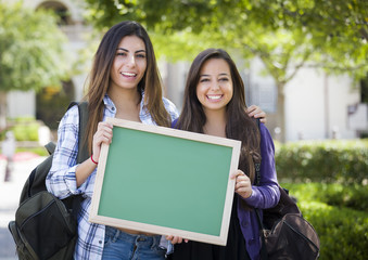 Fototapeta premium Mixed Race Female Students Holding Blank Chalkboard