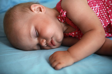 Little baby girl sleeps in the bed
