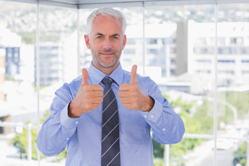 Businessman smiling with his thumbs up