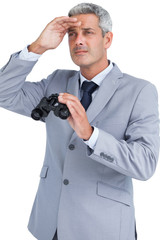 Businessman posing with binoculars and looking away