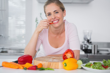 Obraz na płótnie Canvas Cheerful woman eating vegetables