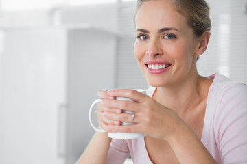 Cheerful blonde having coffee