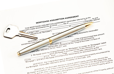 Mortgage assumption agreement with a pen for signature and a key