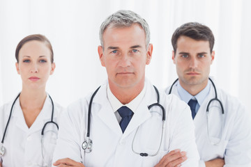 Fototapeta premium Serious doctors posing together crossing arms