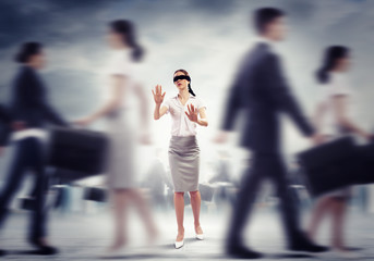 Businesswoman in blindfold among group of people