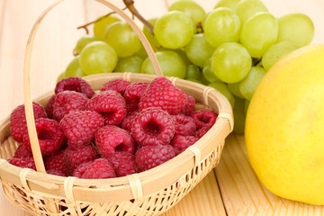ripe sweet grapes and apple on wooden background