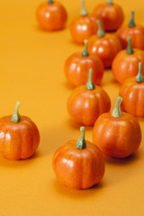 オレンジの背景に複数のカボチャの置物