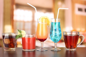 Several glasses of different drinks on bright background