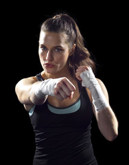 female MMA fighter punching.  black background