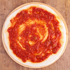 pizza base with tomato sauce