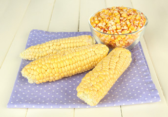 Fresh and dried corn on wooden background