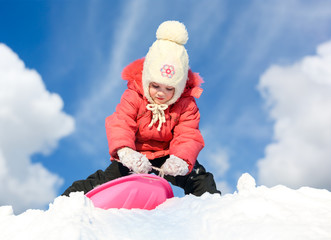 Fototapeta na wymiar Girl with sleds on the hill