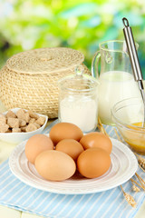 Ingredients for dough on wooden table on natural background