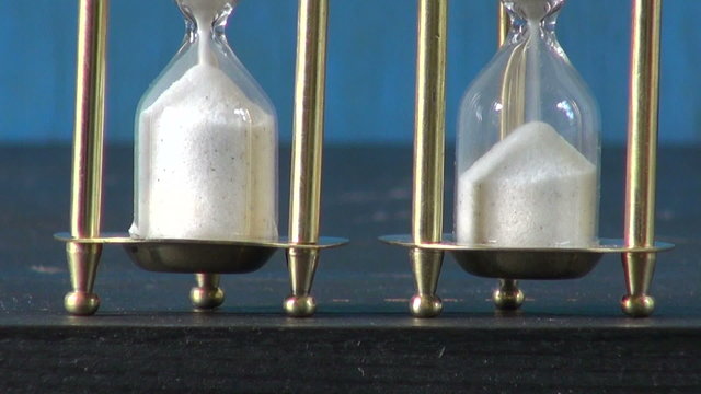 white grain of sand motion in two sandglass. Time concept