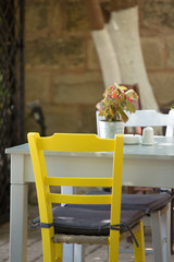 Close-up from a Yellow chair and white table.
