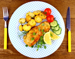 Fried fish fillet with rosemary potatoes and vegetables