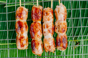 Bratwurst or Hot Dogs on Grill with Flames .