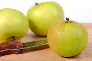 Several green apples and knife