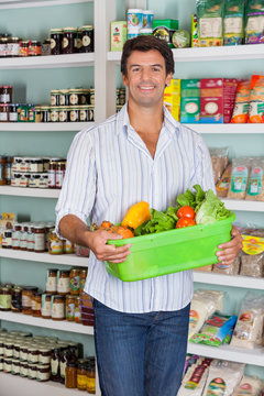 Man Holding Basket Of Vegetables In Supermarket