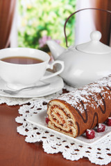 Sweet roll with cup of tea on table in room