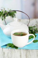 Obraz na płótnie Canvas Teapot and cup of herbal tea with fresh mint flowers