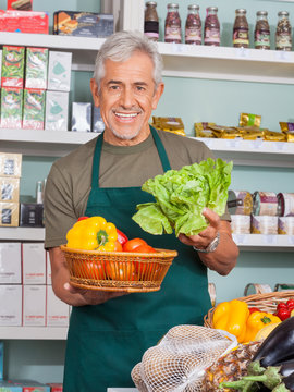 Senior Salesman Selling Vegetables In Store