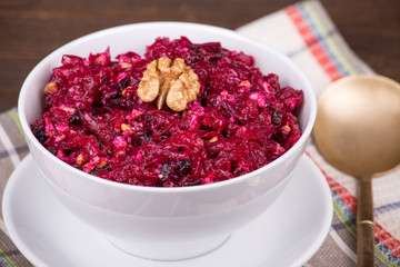 Fresh salad with beet and walnuts on white plate
