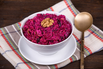 Fresh salad with beet and walnuts on white plate