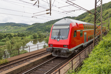 Train driving along river Moselle in Germany