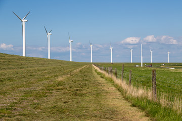 Fototapeta na wymiar Windturbines along a dike in the Netherlands near a motorway