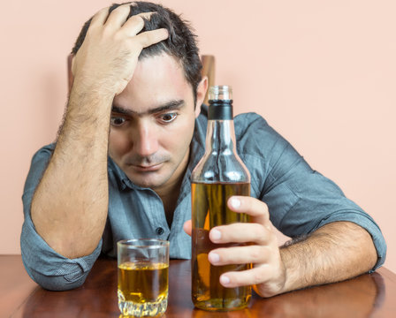 Drunk and depressed hispanic  man suffering a headache