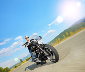 Biker riding a customized motorcycle on an open road