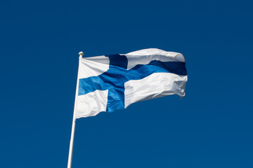 Flagge von Finnland vor blauem Himmel.