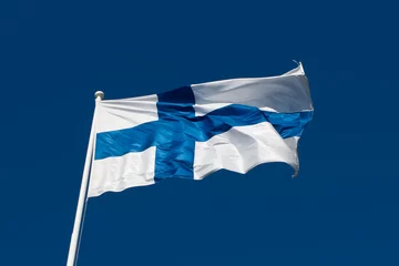 Rolgordijnen Flag of Finland before blue sky. © jnelnea