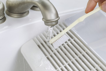 Hand cleaning fan vent cover in sink