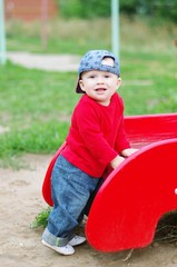 nice baby boy age of 10 months on playground in summer