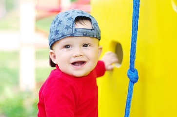happy baby boy on playground in summertime