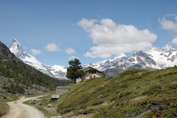 Fototapeta na wymiar Matterhorn rising above hut and path in Swiss Alps