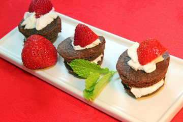Chocolate brownie cakes with strawberries and whipped cream