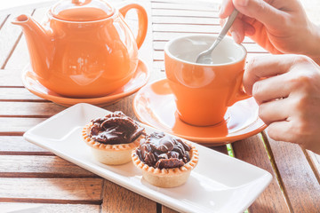 Hot cup of white tea and crispy chocolate tarts