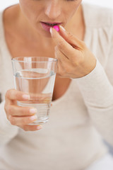 Obraz na płótnie Canvas Closeup on young woman eating pill