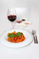 Delicious pasta and red wine served for dinner