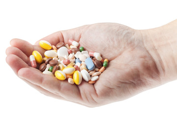 Man's hand holding a handful of medicine pills