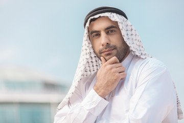 Thoughtful Arab businessman. Confident Arab businessman holding