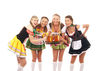 Obraz premium Four young women in Bavarian clothes holding glasses of beer