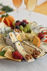 Delicacies. Food composition - hard and soft cheese varieties and fruits.