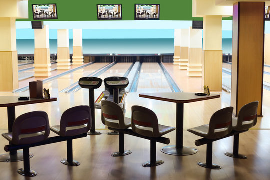 Small light bowling with hanging displays, table and chairs.